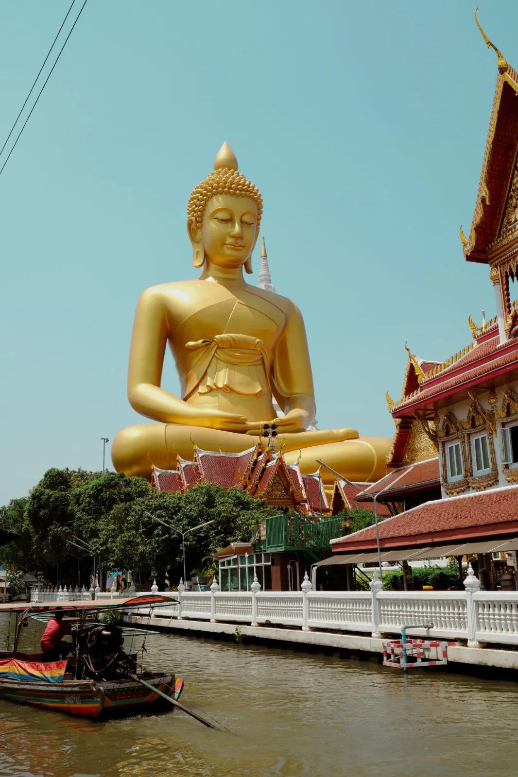 Golden Buddha statue beside a temple