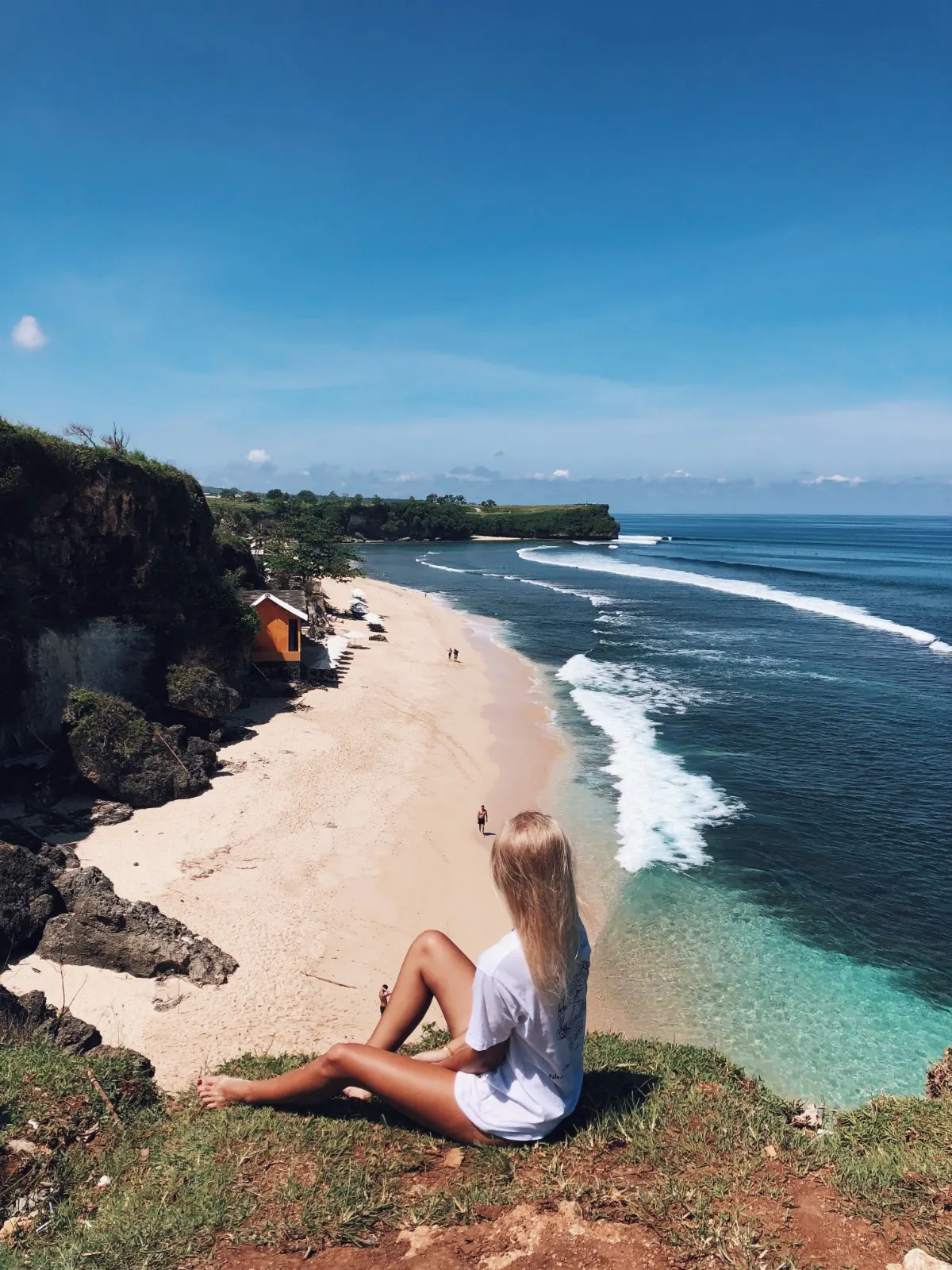 Traveller looking over a beautiful white sand beach and turquoise sea