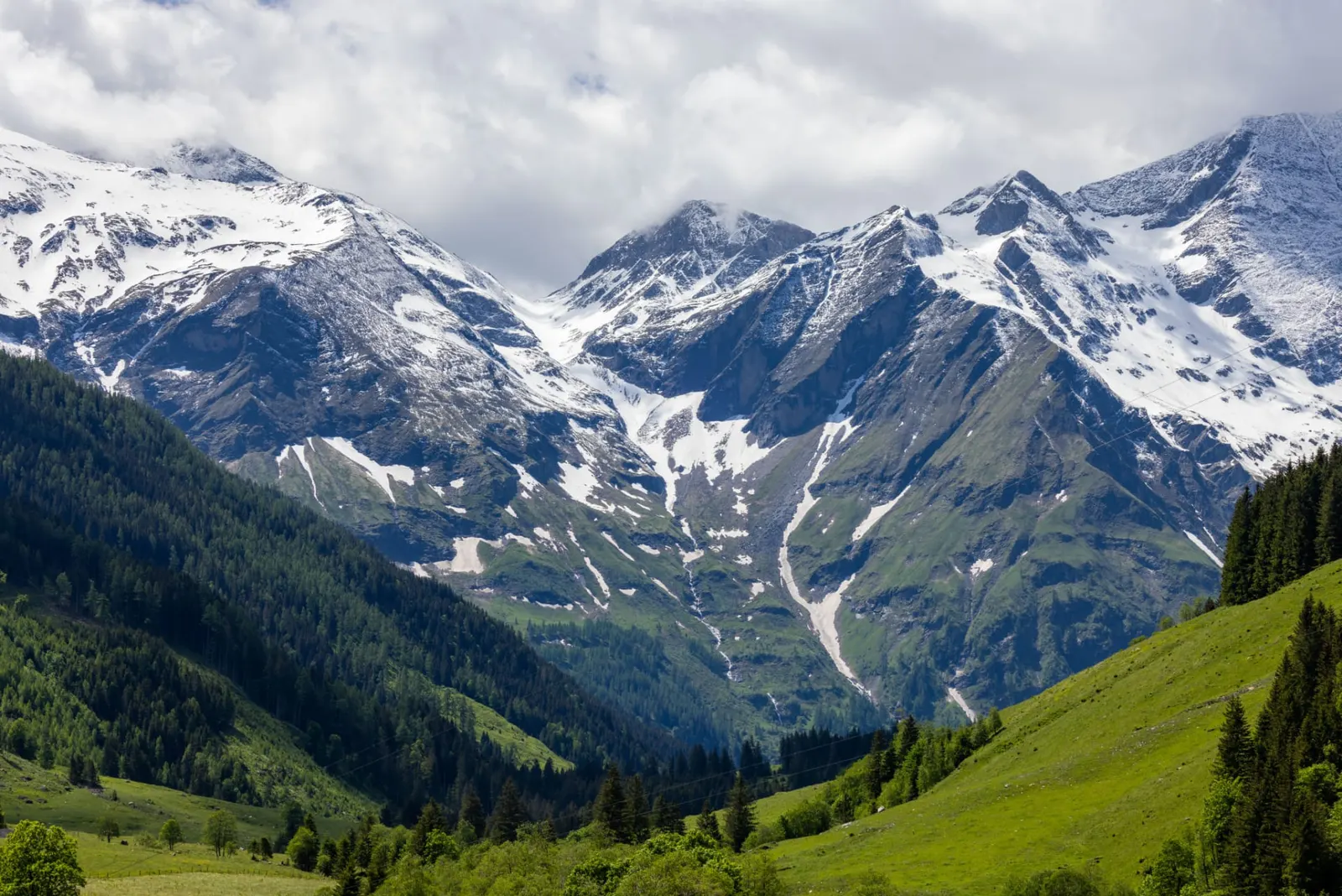Snow-capped mountains above green valleys